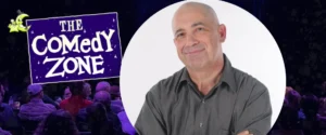 Comedian Sid Davis smiling confidently, beside "The Comedy Zone" logo and audience.