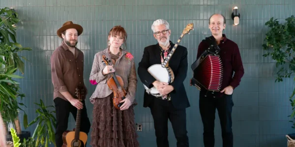 Four musicians, members of Solas, posing with their instruments. For their traditional Irish concert.