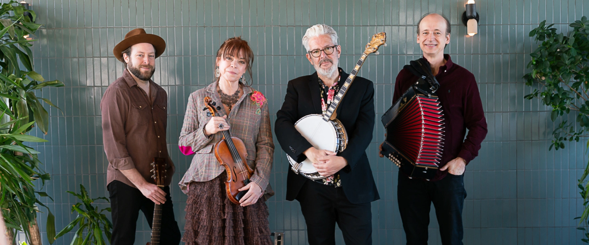 Four musicians, members of Solas, posing with their instruments. For their traditional Irish concert.