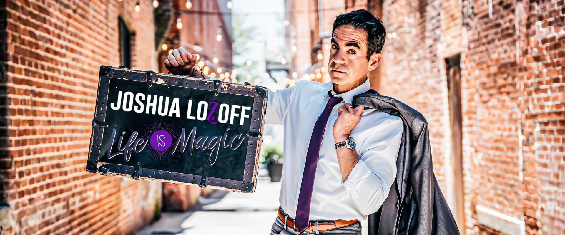 Magician Josh Lozoff holding a sign for his