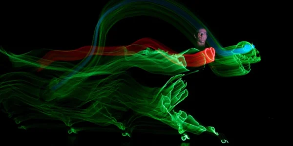 Actor light painting a green dinosaur