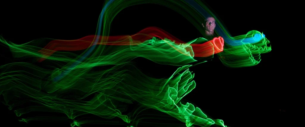 Actor light painting a green dinosaur