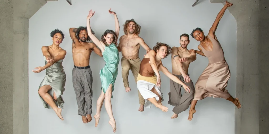 Photo: seven dancers from BODYTRAFFIC posed jumping in mid-air