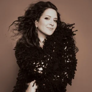 Photo: Nicole Zuraitis in a shiny black dress, photo is sepia toned