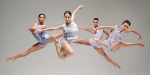 Photo: four female dancers posed jumping in mid-air