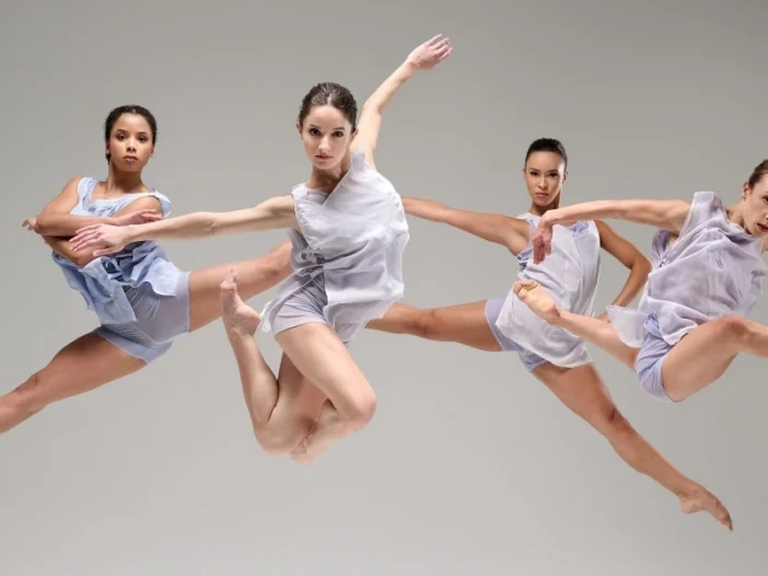 Photo: four female dancers posed jumping in mid-air