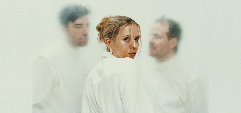Photo: two men and one woman of Stundom; photo has a moody, off-white colorcast