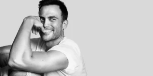 Photo: studio headshot of Cheyenne Jackson smiling at camera